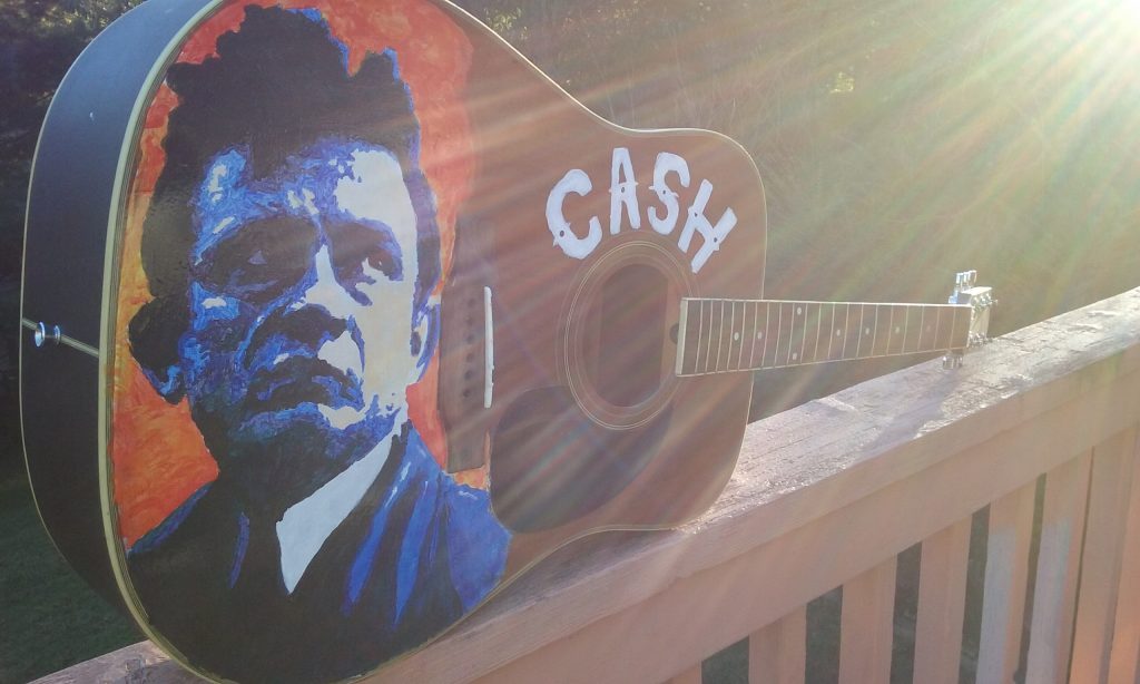 A guitar painted with an image of Johnny Cash